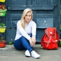 Dziewczyna siedzi obok plecaka
